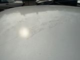 cars parked in a parking lot with a lot of snow on the roof