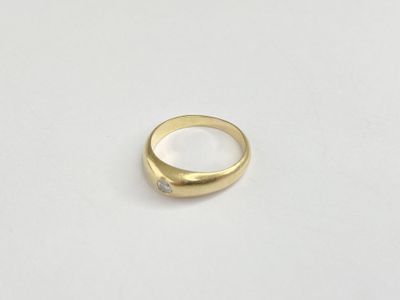 a close up of a gold ring on a white surface
