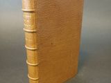 an old book sitting on top of a table next to a gray background