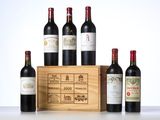 several bottles of wine sit in front of a wooden box