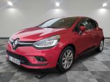 une voiture rouge est garée dans une pièce au sol en damier