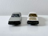 deux petites voitures posées sur une table