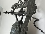 a bell that has a chain around it and a bird on top of it