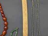 several different necklaces and bracelets are displayed on a table