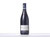 a bottle of wine sitting on top of a table next to a white wall