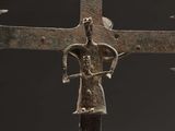 a close up of a metal cross with a person on it