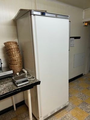 un réfrigérateur blanc dans une cuisine avec un plan de travail noir