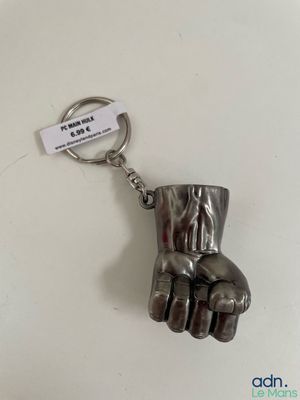 a metal keychain with a metal hand holding a key