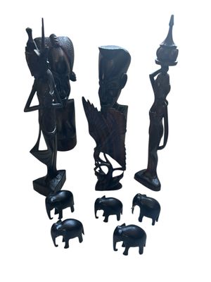 three wooden statues of elephants and a woman with a basket