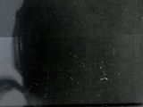 three stamps of different sizes and colors on a black surface