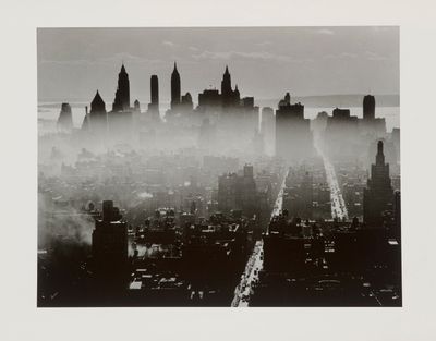 black and white photograph of a city skyline with fog in the air
