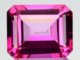 un gros plan d'une pierre précieuse rose sur une surface blanche