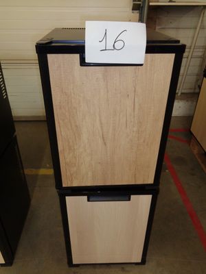 a black and white refrigerator with a sign on it