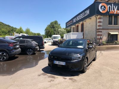 a black car parked in front of a building in a parking lot
