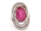 a close up of a ring with a pink stone surrounded by diamonds