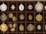 many different types of silver and gold medals in a display case
