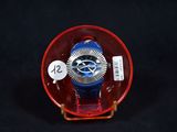 a red and blue watch sitting in a glass container