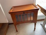 a small wooden table with a glass door on it