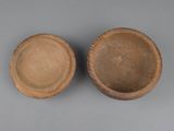 two brown bowls sitting next to each other on top of a gray surface