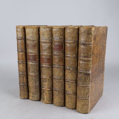 cinq vieux livres sont empilés les uns sur les autres sur une table