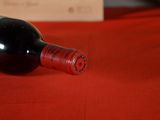 a bottle of wine sitting on a red table cloth