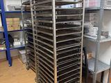 a metal rack with many trays of food on it