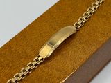an image of a gold bracelet with a clasp on a wooden box