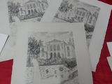 four drawings of a house on a red sheet of paper on a table