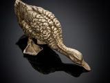 an image of a bronze figurine of a duck on a black surface