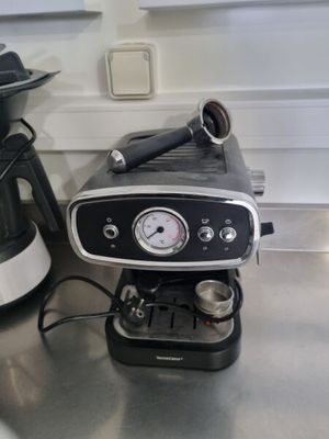 une cafetière noire et argentée posée sur le plan de travail de la cuisine