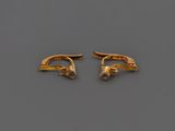 une paire de boucles d'oreilles en or serties de diamants sur un fond gris