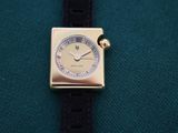 a close up of a watch on a green cloth