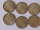 six pièces de monnaie britanniques empilées les unes sur les autres sur une surface blanche