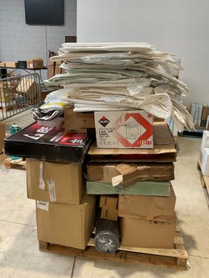a pile of boxes sitting on a pallet in the middle of a room