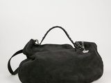 le grand sac noir est posé sur une surface blanche