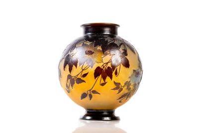 a yellow vase with black and white flowers on it