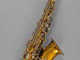 an old saxophone with a gold plated body on a gray background