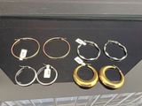 plusieurs paires de boucles d'oreilles créoles en or et en argent exposées dans une vitrine