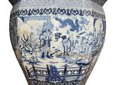a large blue and white vase with a picture of people on it