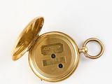an image of a gold pocket watch with a key on a white surface