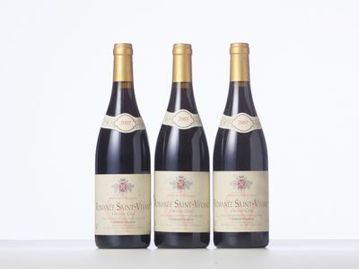 three bottles of wine are lined up on a table