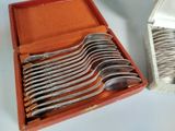 a lot of silver spoons in a red box