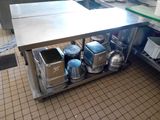 a large stainless steel table with pots and pans on it