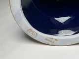 a blue and white vase sitting on a white table