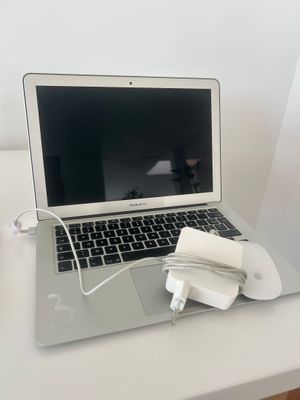 un ordinateur portable posé sur un bureau avec une souris
