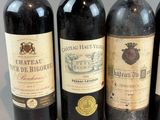 four bottles of red wine are lined up on a table