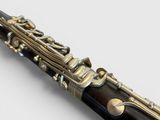 close up view of a clarinet with a wooden body and brass plated body