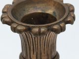 a metal vase that is sitting on top of a table
