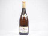 une bouteille de vin blanc posée sur une table blanche