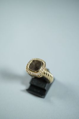 un gros plan d'une bague en or sertie d'une pierre marron